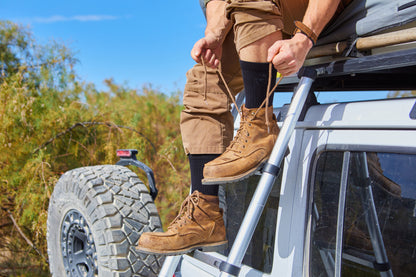 Outdoorsman lacing up boots with OPR Socks